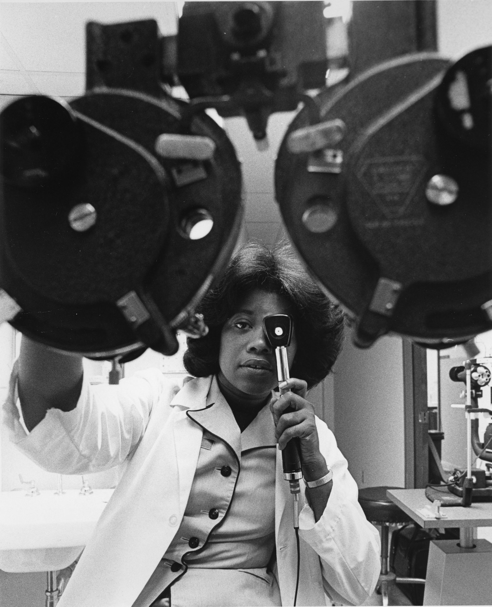 Optometrist examining a patient's eye with diagnostic equipment during an eye exam